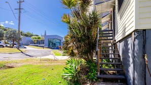 A residential building with a staircase leading to a balcony, surrounded by greenery and a clear sky. - The Normanby - For the traveller on a budget (Yeppoon)