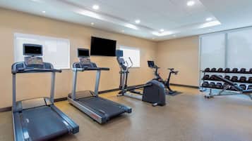 A gym with treadmills, an elliptical, and a weight bench.