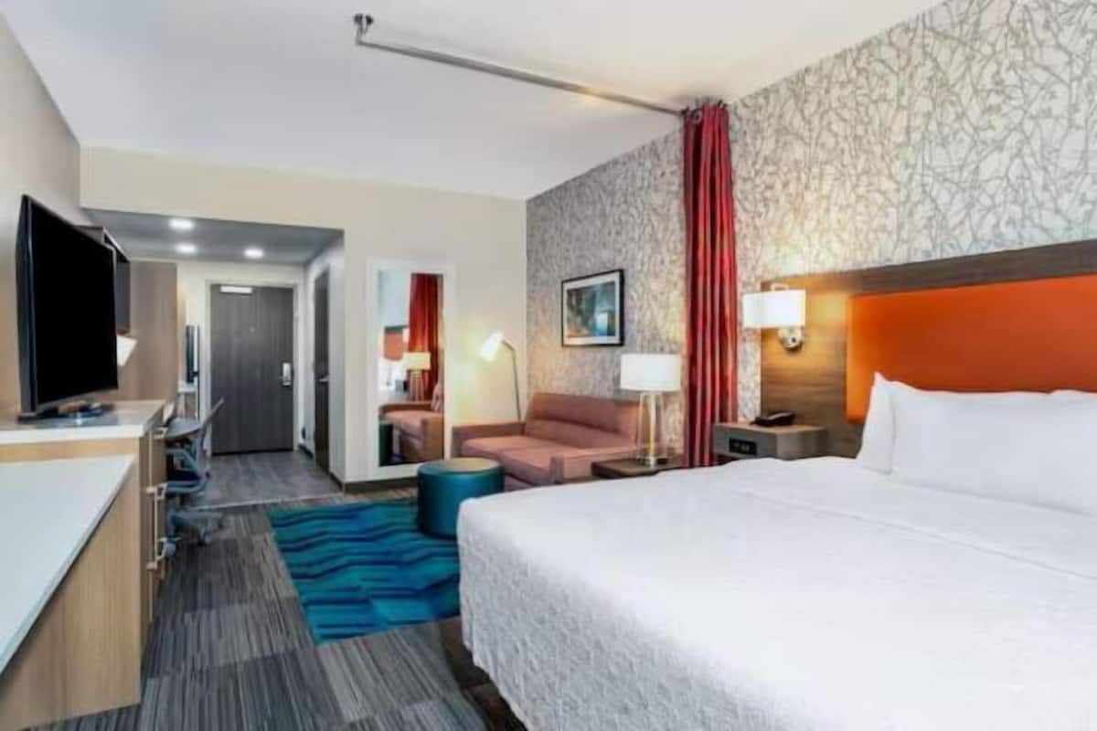 Escritorio, cortinas blackout y tabla de planchar con plancha