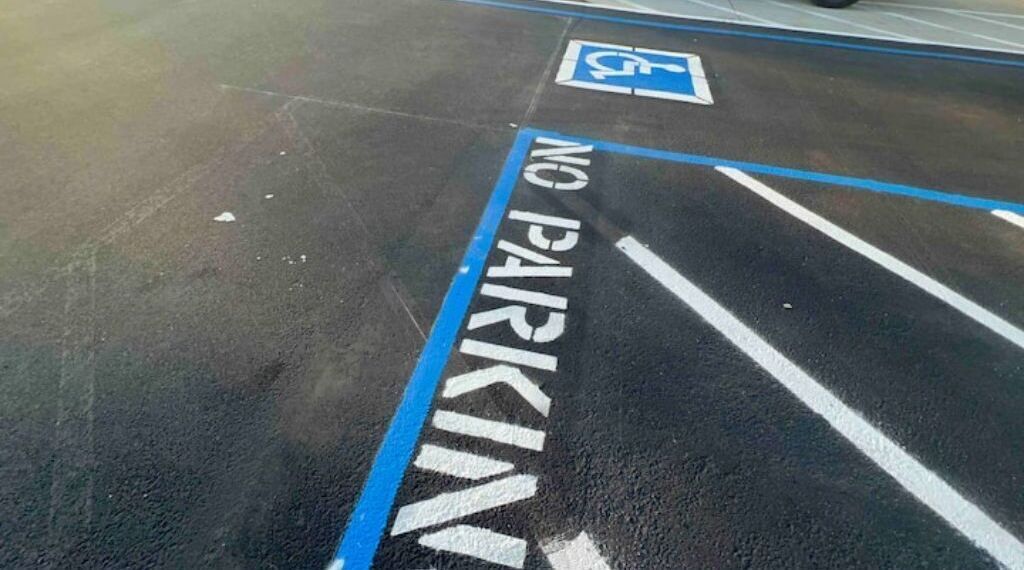 A parking area with a blue line marked "NO PARKING" and a wheelchair accessibility symbol.