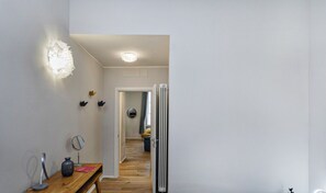 A modern, minimalist room with a wooden desk, a bed, and a radiator.