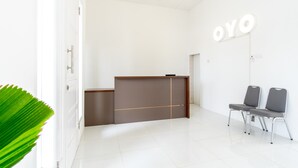 Un área de recepción con mostrador, dos sillas y un cartel que dice "OYO".