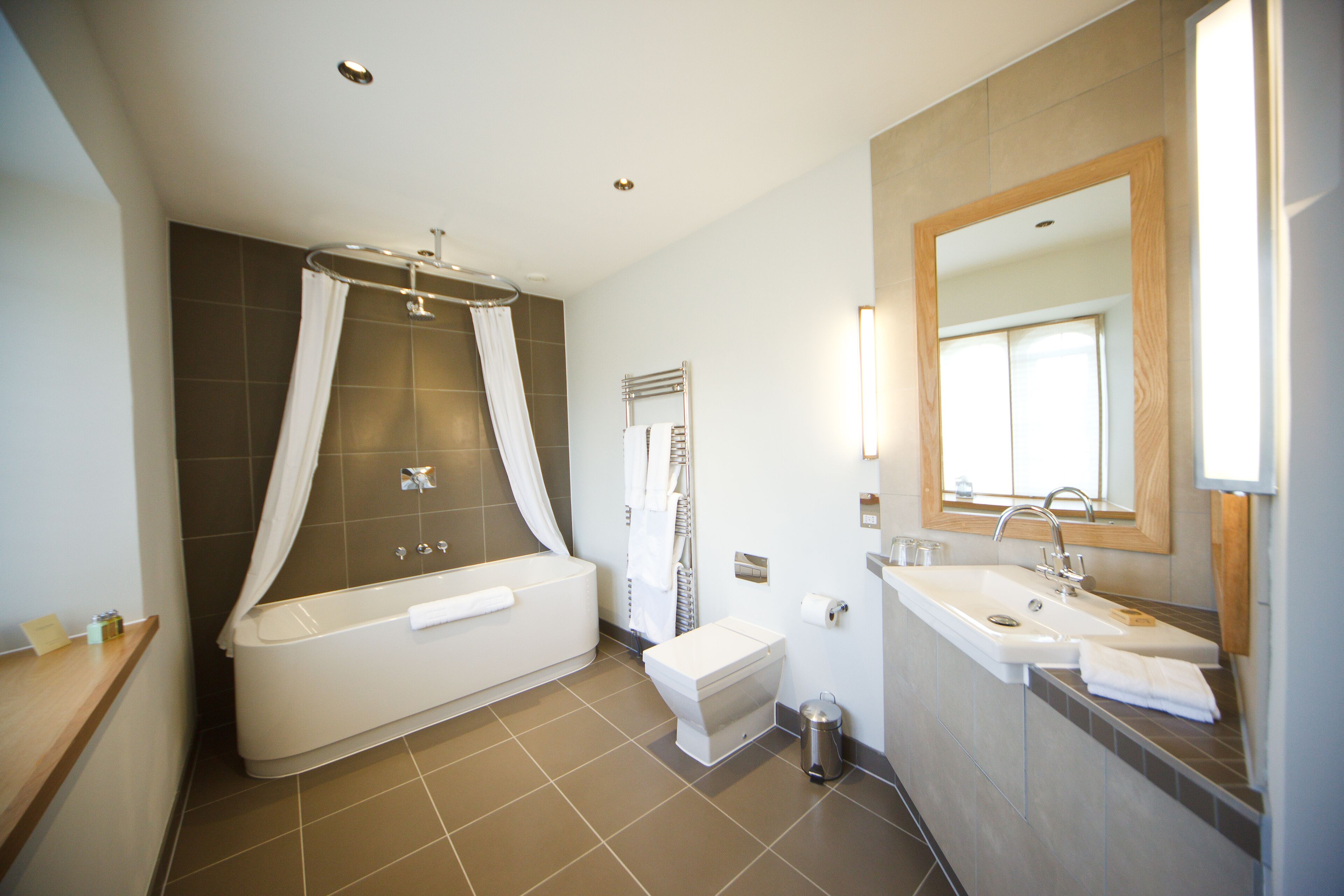 A modern bathroom with a bathtub, toilet, and sink.
