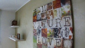 Un mur orné d’un collage de panneaux aux textures variées, formant les mots « DE LA NATURE, AVEC AMOUR ».