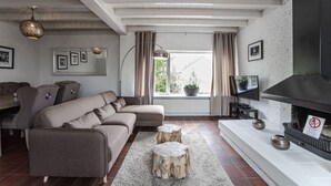 A modern living room with a sectional sofa, a fireplace, and a large window with curtains.