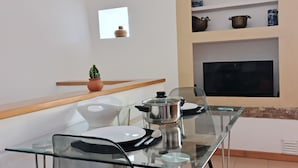 Eine moderne Küche mit einem Glastisch, einem eingebauten Ofen und einem kleinen Fenster.