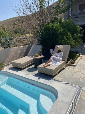 En säsongsöppen utomhuspool och solstolar