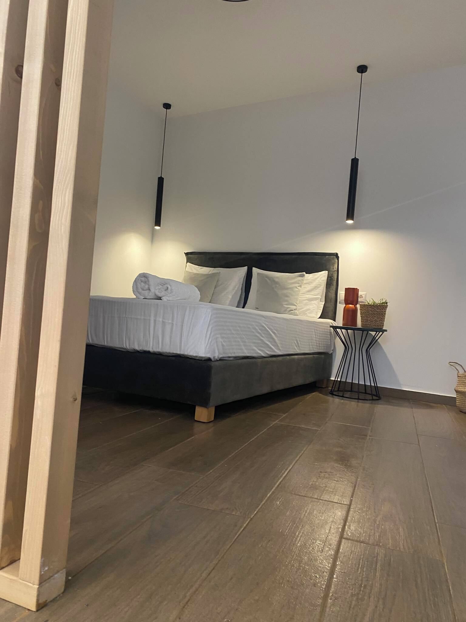 Een moderne slaapkamer met een bed, nachtkastjes en hanglampen.