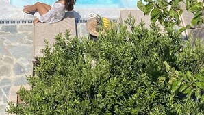 Una piscina rectangular con una persona sentada en el borde.