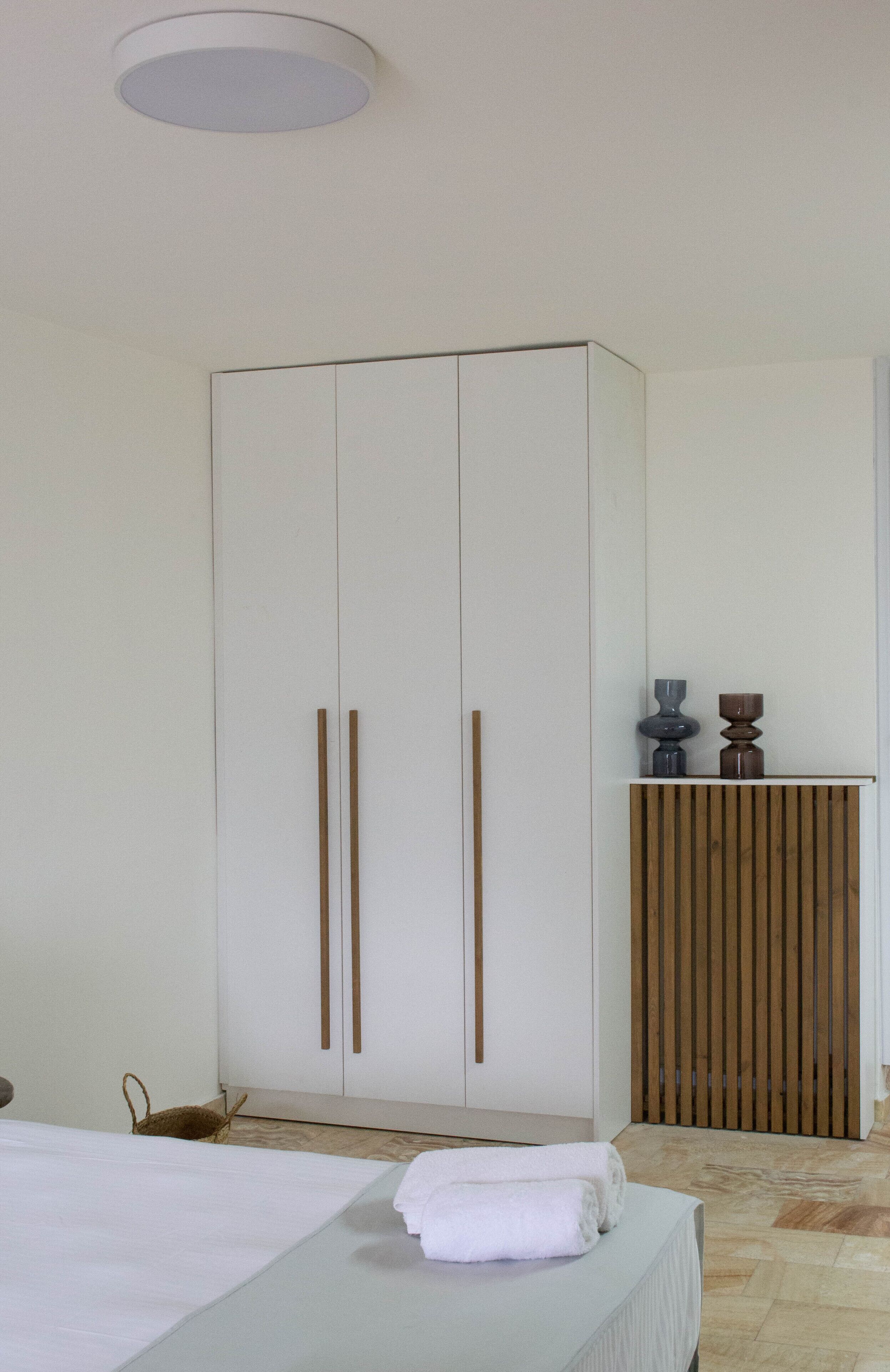 Une chambre à coucher avec un lit, une armoire et une table de chevet.