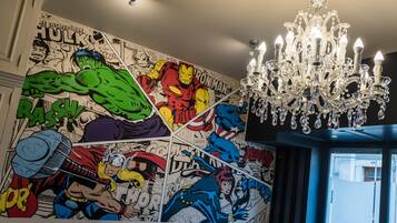 Ein Zimmer mit Wandgemälde im Comic-Stil und einem Kronleuchter.