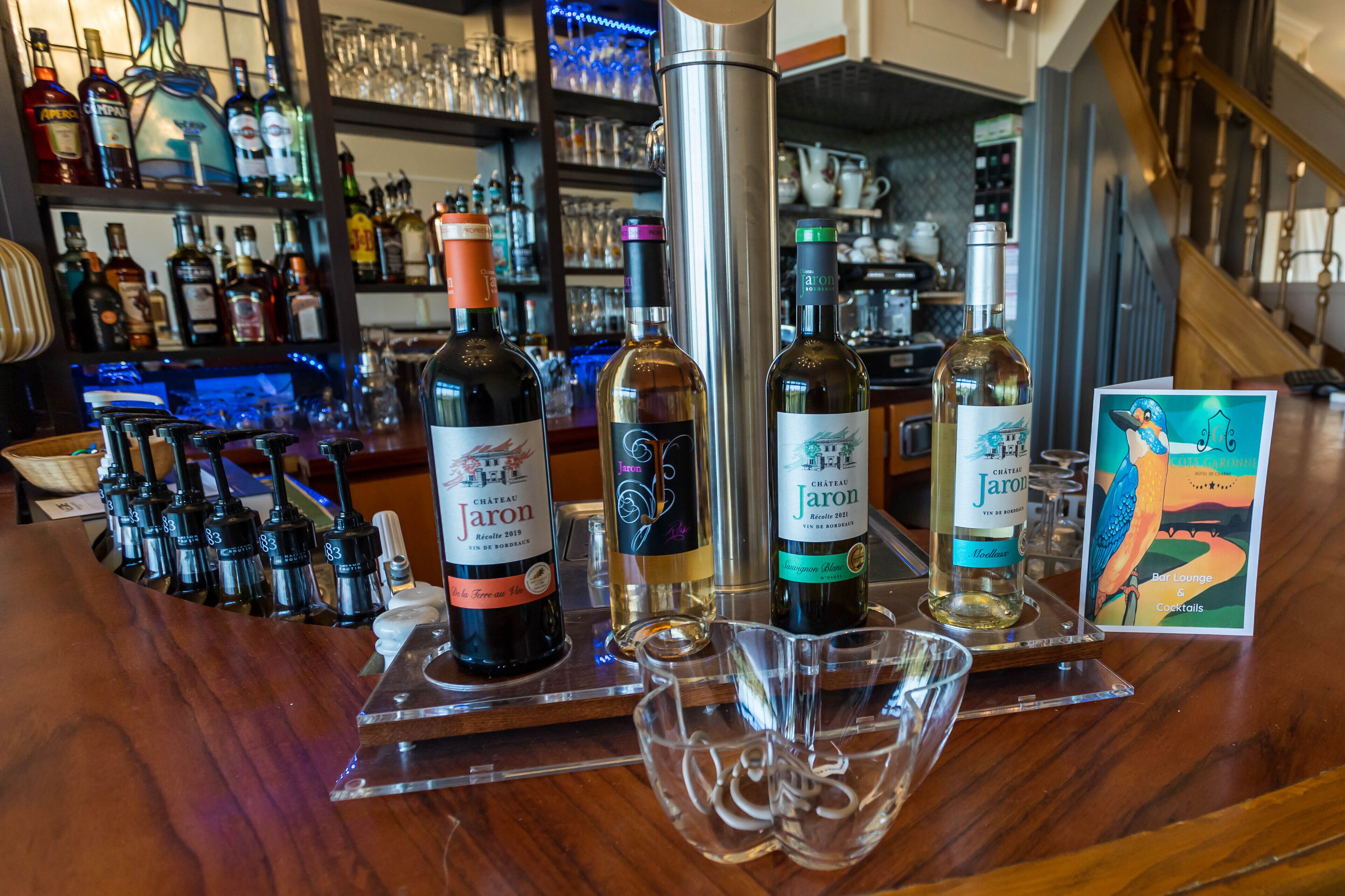 Una zona de bar con varias botellas de vino Chateau Jaron y copas.