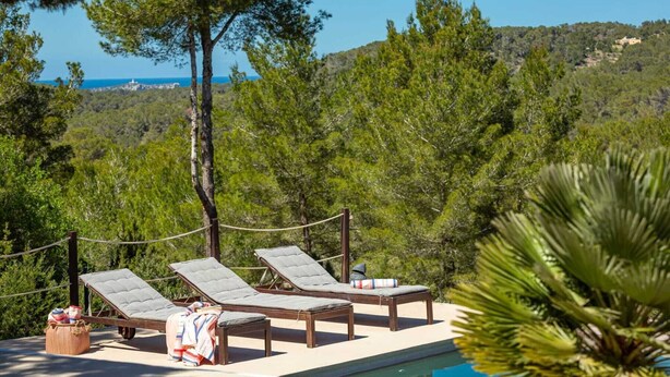 A poolside area with lounge chairs and a view of the sea. - SES SAVINES A charming, peaceful house with a pool and BBQ, 2km from the beach (Illes Balears)