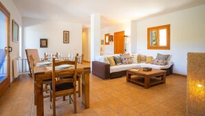 A spacious living area with a dining table, chairs, a sofa, and a coffee table. - SES SAVINES A charming, peaceful house with a pool and BBQ, 2km from the beach (Illes Balears)