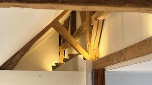 A room with exposed wooden beams and a white ceiling.
