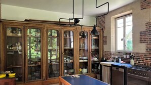 A kitchen with wooden cabinets, a blue table, and a gas stove.