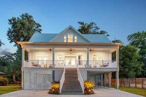 A two-story house with a front porch, a staircase, and a fenced yard. - 6BR Estate & Cottage | Hot Tub | Near Beach (Savannah)