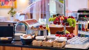 Un bufé con una variedad de alimentos, como frutas, pan y bebidas.
