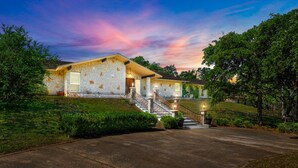 A stone house with a staircase leading to the entrance, surrounded by greenery. - Peaceful Retreat near Lake Travis & Volente (Volente)