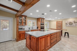 Une cuisine spacieuse avec des meubles en bois, un grand îlot central et des appareils électroménagers intégrés.