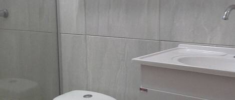 A bathroom with a toilet, a sink, and a shower.