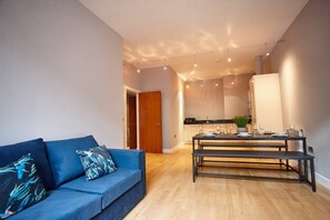 Relax in a comfortable living space with a sofa, dining table, and kitchen area.