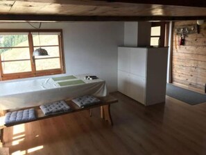 Cozy retreat with a bed, table, and wardrobe, offering a peaceful space to rest.
