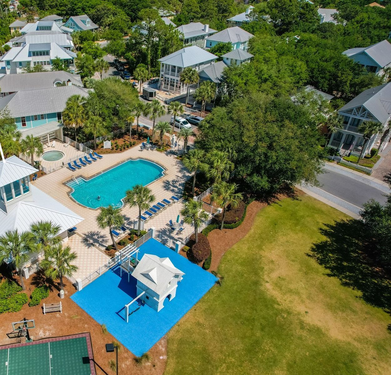 An aerial view of Bellview Park & Pool, featuring a large swimming pool, multiple lounge areas, and a variety of buildings surrounded by lush greenery.