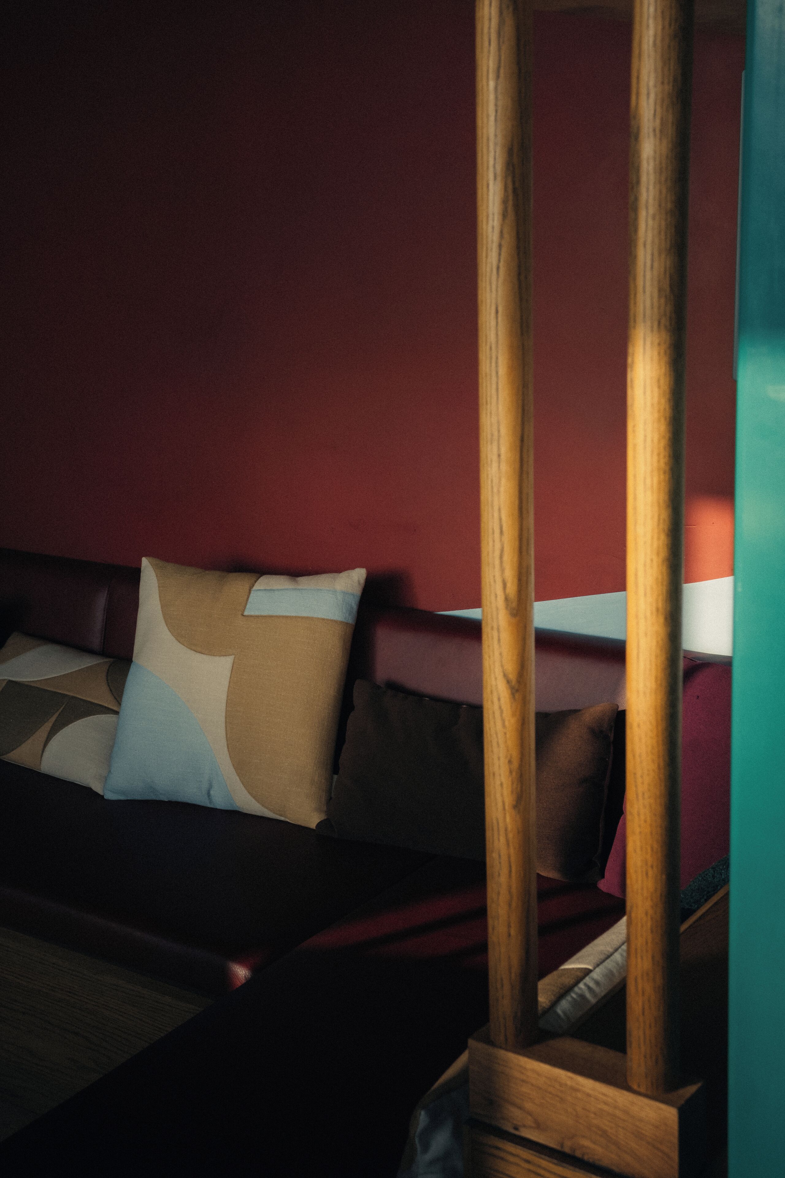 Una stanza con un letto, una testiera in legno e una parete rossa.