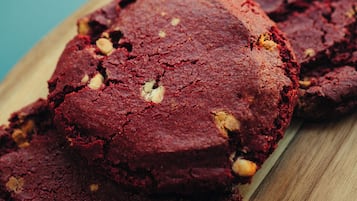 A wooden board with several round, dark-colored cookies.