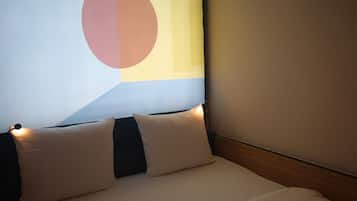 Una habitación de hotel con una cama, almohadas y una pared con diseño geométrico.