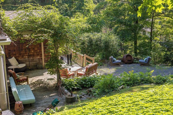 A wooden deck with outdoor furniture, a small wooden structure, and a garden area with plants. - Classic Stockbridge Cottage (Stockbridge)