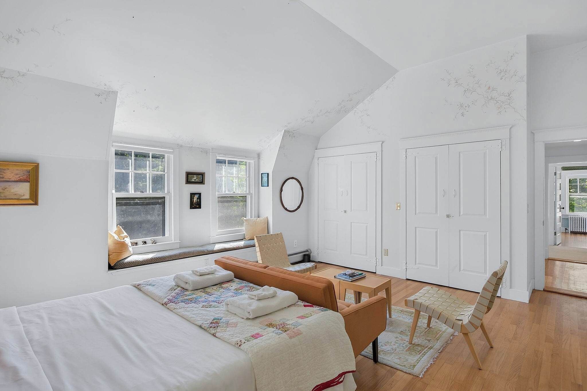 Une chambre à coucher avec un lit, un bureau, une chaise et une fenêtre.