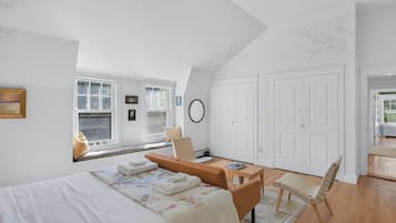 Une chambre à coucher avec un lit, un bureau, une chaise et une fenêtre.