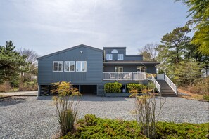 Een huis met twee verdiepingen, een balkon, een overdekte veranda en een trap naar de bovenverdieping.