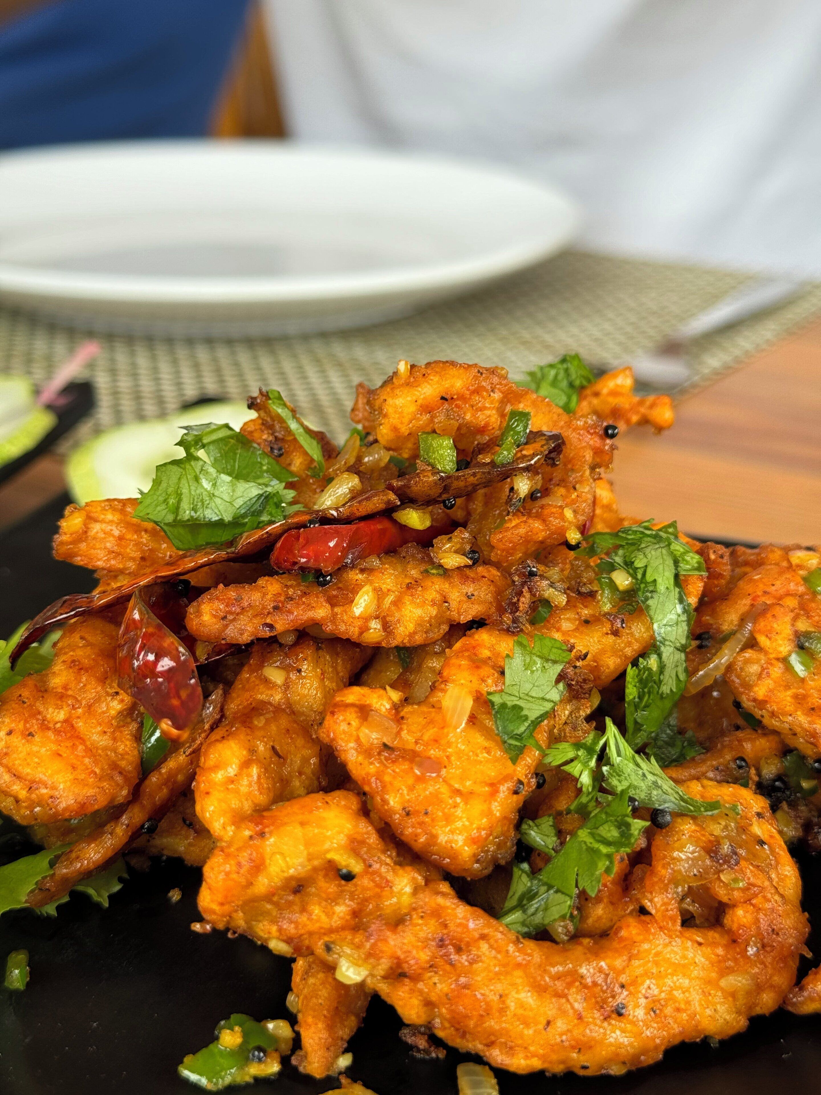 A plate of fried chicken garnished with herbs and spices.