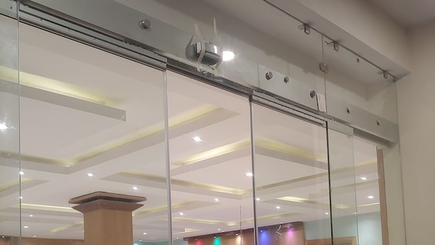 Un hall d’entrée spacieux, doté d’un comptoir d’accueil, d’une grande colonne en bois et d’une scène éclairée de couleurs vives.
