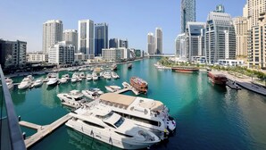 A marina with several yachts docked, surrounded by modern high-rise buildings. - Stella Maris Tower (Dubai)