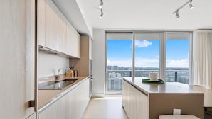 A modern kitchen with a large window, a sink, and a countertop.