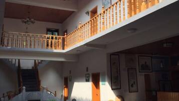 A multi-level interior with a staircase, wooden railings, and a chandelier.