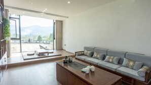 Una sala moderna con sofá, mesa de centro y vistas al exterior.