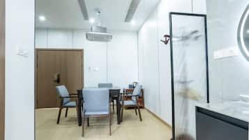 A modern meeting room with a wooden door, a round table, and four chairs.