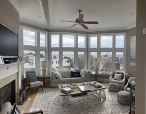 Relax in this stylish living room with a fireplace, large windows, and comfortable seating.
