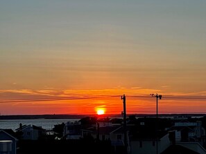 Enjoy breathtaking views of the setting sun over a serene residential area.