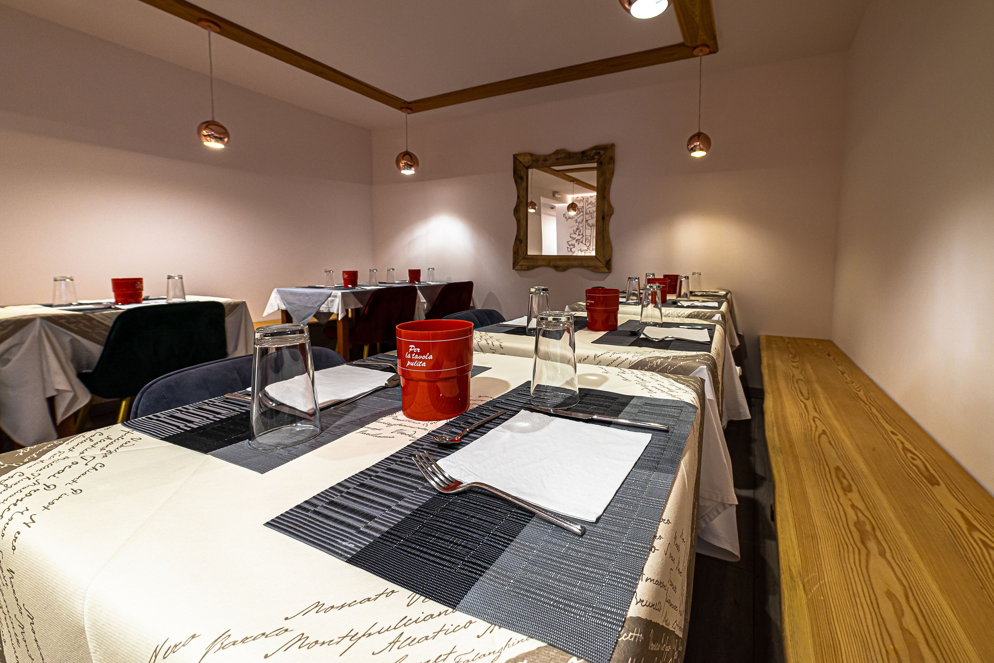 A dining area with tables set for meals, including red cups and cutlery.