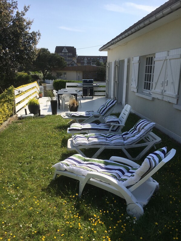 A patio with lounge chairs and a barbecue grill. - Beautiful villa with ocean views, 50 meters from the beach near Le Home (Varaville)