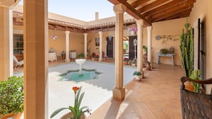 A covered courtyard with a central fountain, potted plants, and a cactus. - Fantastic Rural Villa Korema: 8 pax Between SHorta and Portocolom (Portocolom)