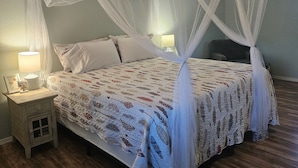 A bedroom with a canopy bed, a bedside table with a lamp, and a nightstand. - The Wee Nook, just 3 miles from Carver Landing! (Piercetown)