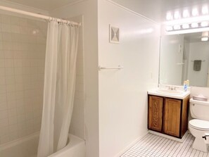 Un baño con ducha, lavamanos e inodoro.