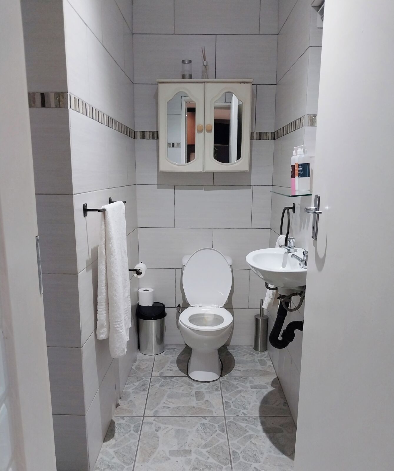 Ein Badezimmer mit Toilette, Waschbecken und Spiegel.